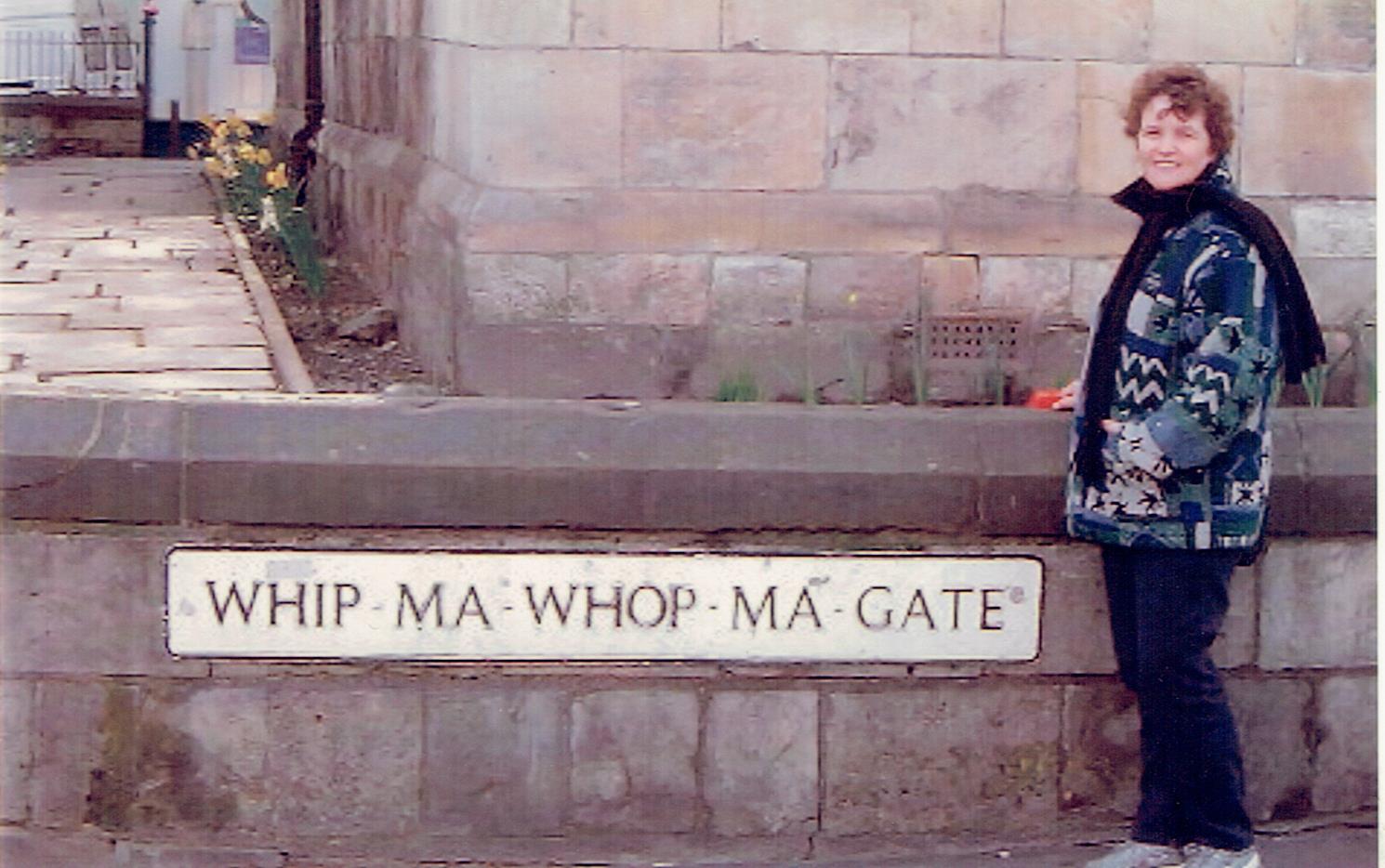 Travel sometimes results in unintended consequences. This image shows a female standing beside a road name in England. Whipmawhopmagate!