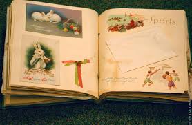 An open book showing photographs on a layout using ribbons, cards and heritage scrapbooking material. 