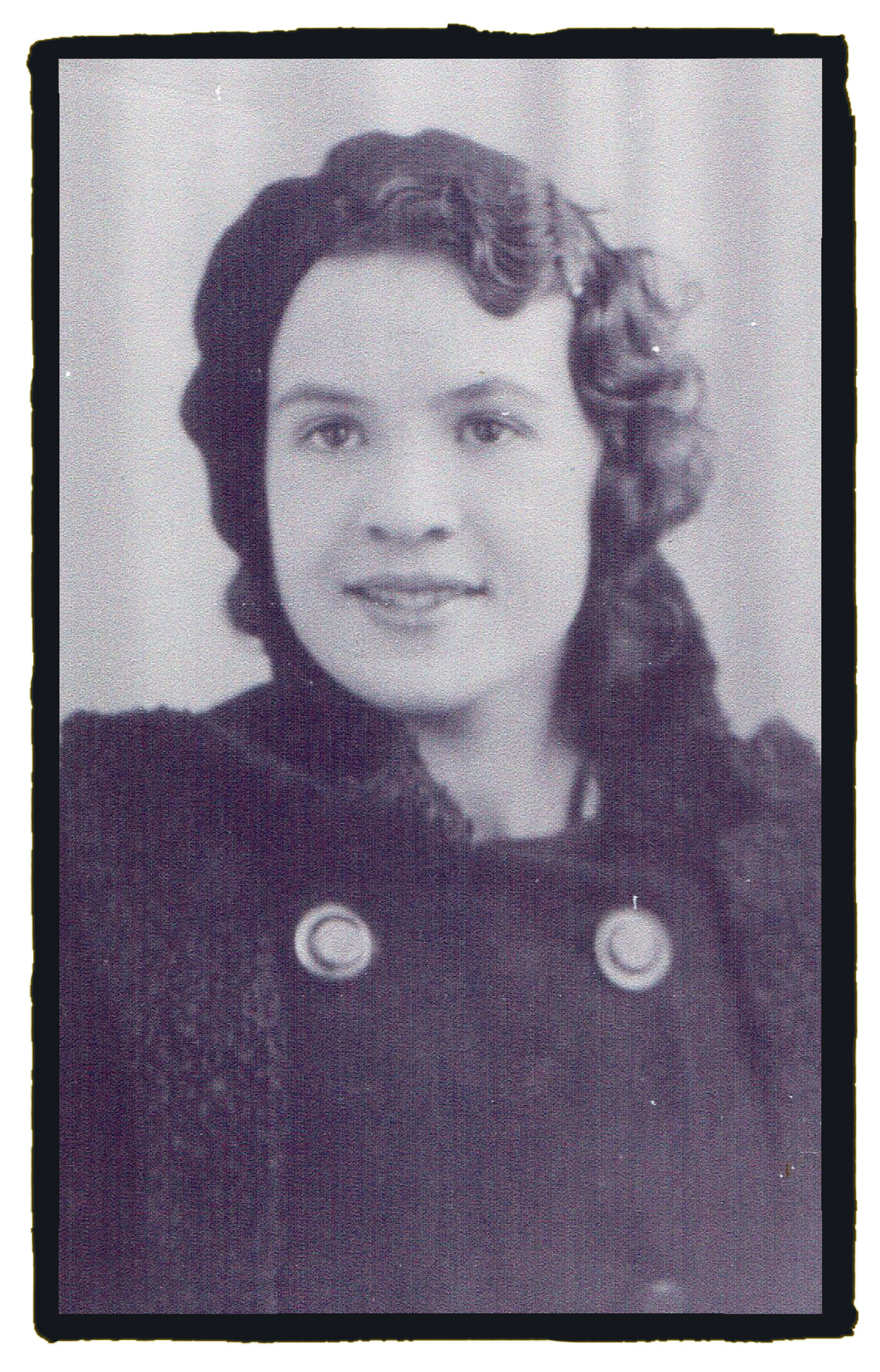 Black and white photograph of a young women taken c 1935. She has wavy dark hair and dark brown eyes.
