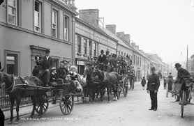 A 1920 image of two horse drawn charabancs filled with people.