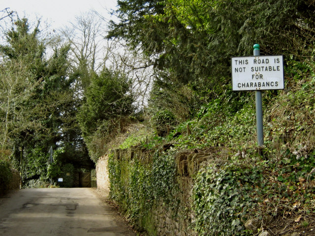 A narrow English country road showing a road sign warning, "Not suitable for charabancs"