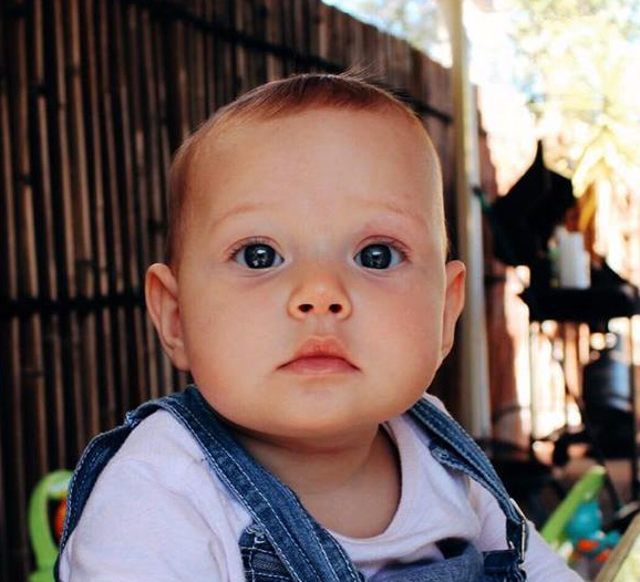 Head and shoulders image of a young child with grey eyes